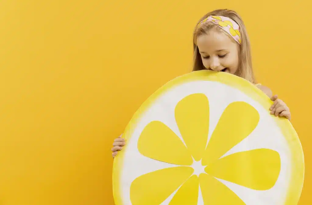 Enfant croquant un citron